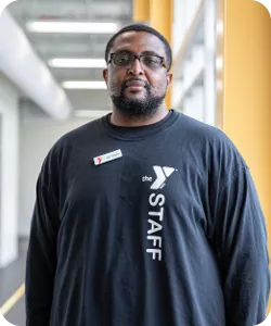 Antonio Lang, a personal trainer at the Hayes-Taylor YMCA, poses for a photo. He is wearing glasses and smiling at the camera.