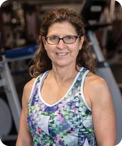 A portrait of Lori Ecklund, personal trainer at the Ragsdale YMCA. She is wearing glasses and smiling at the camera.